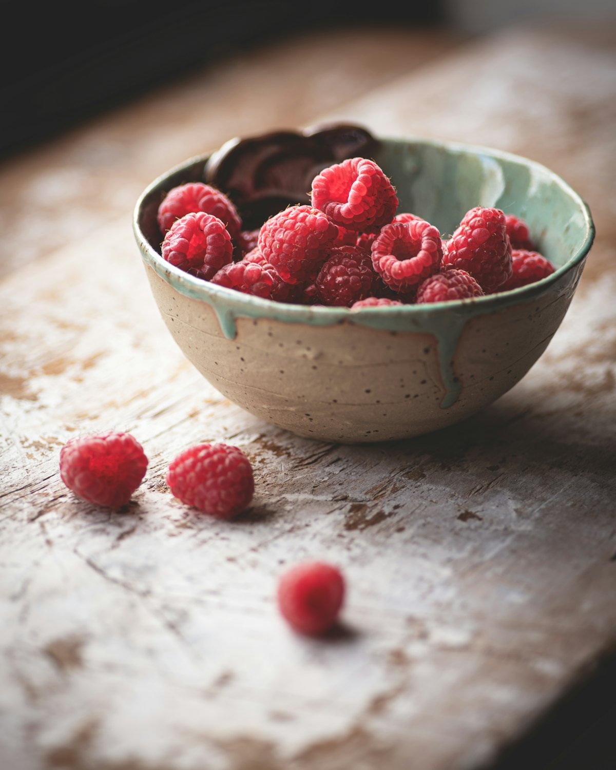 Eine Schale frischer Himbeeren auf einem Holztisch